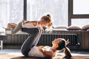Mutter balanciert ihre Tochter beim Yoga